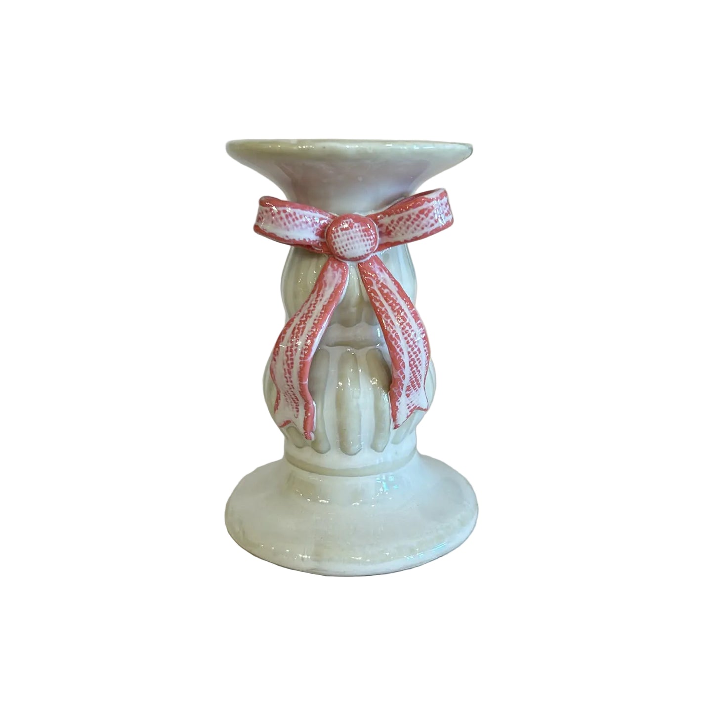 Small white candle holder with a pink ribbon on a light surface.