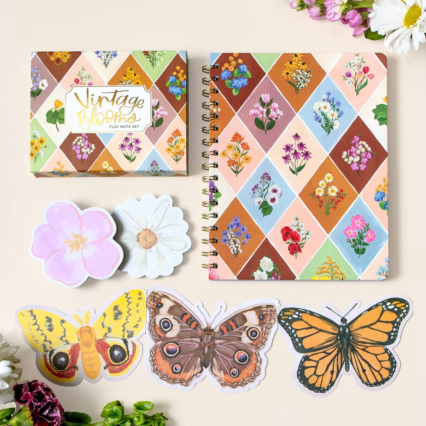 Notebook with floral design, matching stickers of flowers and butterflies on a light background.