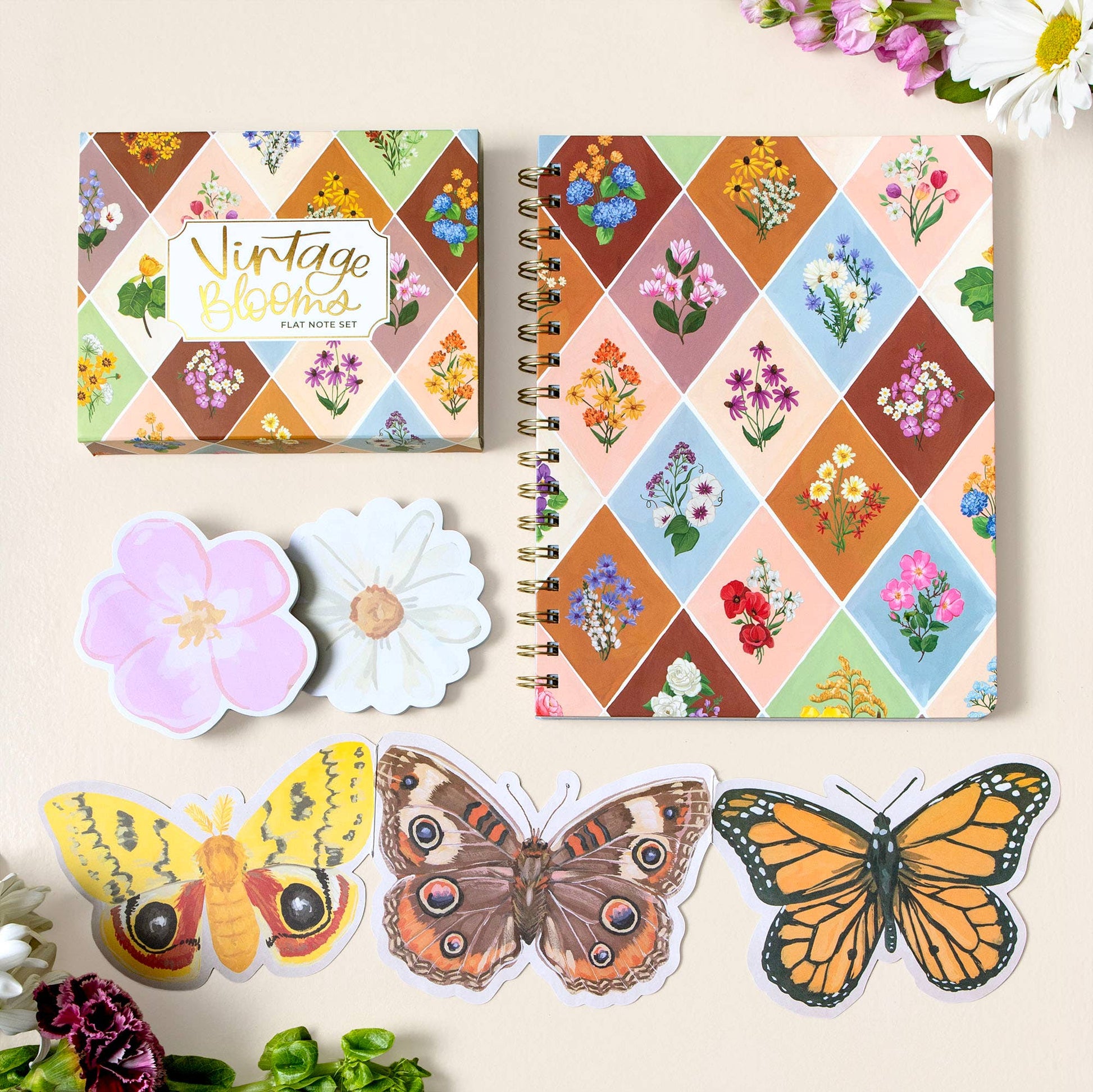 Notebook with floral design, matching stickers of flowers and butterflies on a light background.
