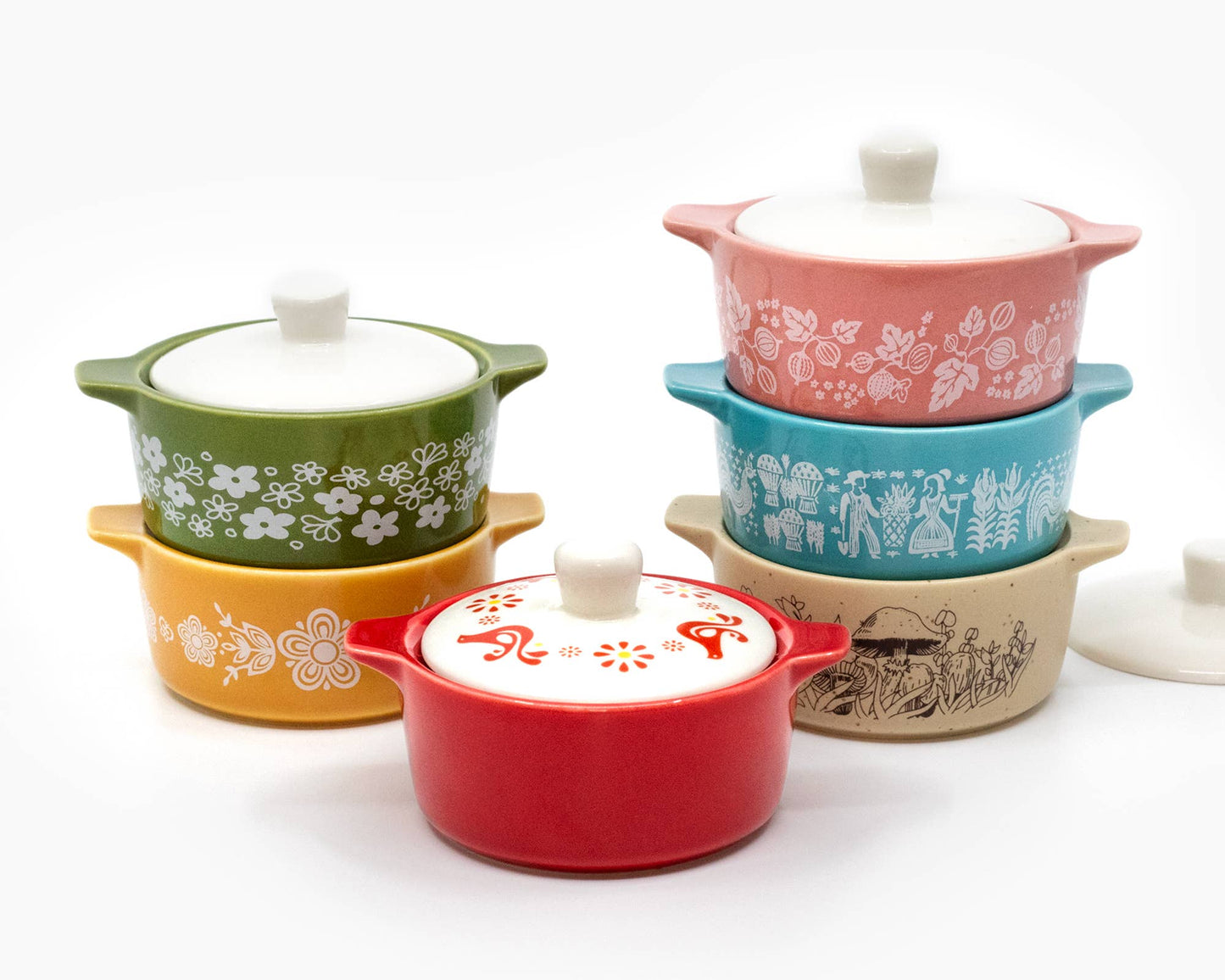 Set of colorful ceramic pots with lids on a white background
