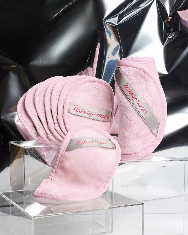 Pink makeup erasers with 'Makeup Eraser' branding on a reflective surface.