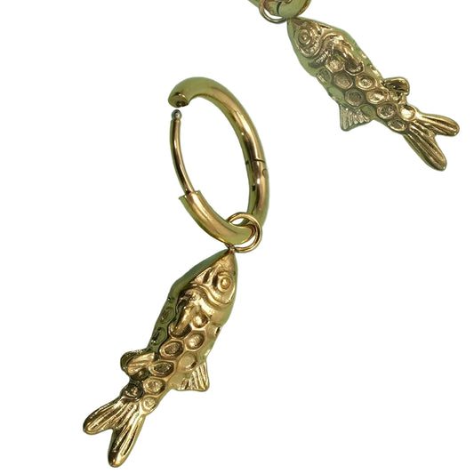 Two gold, fish shaped charm drop earrings on a white background