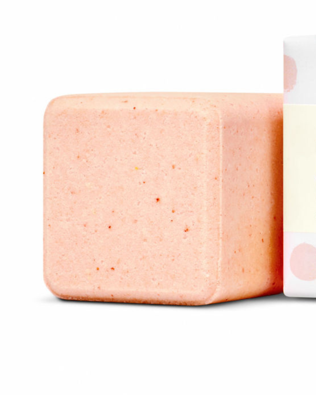 Pink bath bomb with a white container on a light gray background