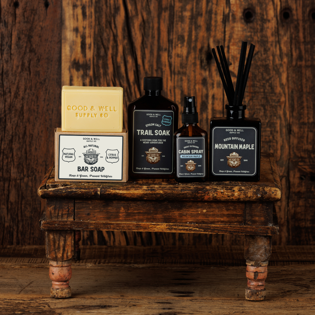 Collection of natural products including soap, soaps, and sprays on a wooden shelf with a rustic background.