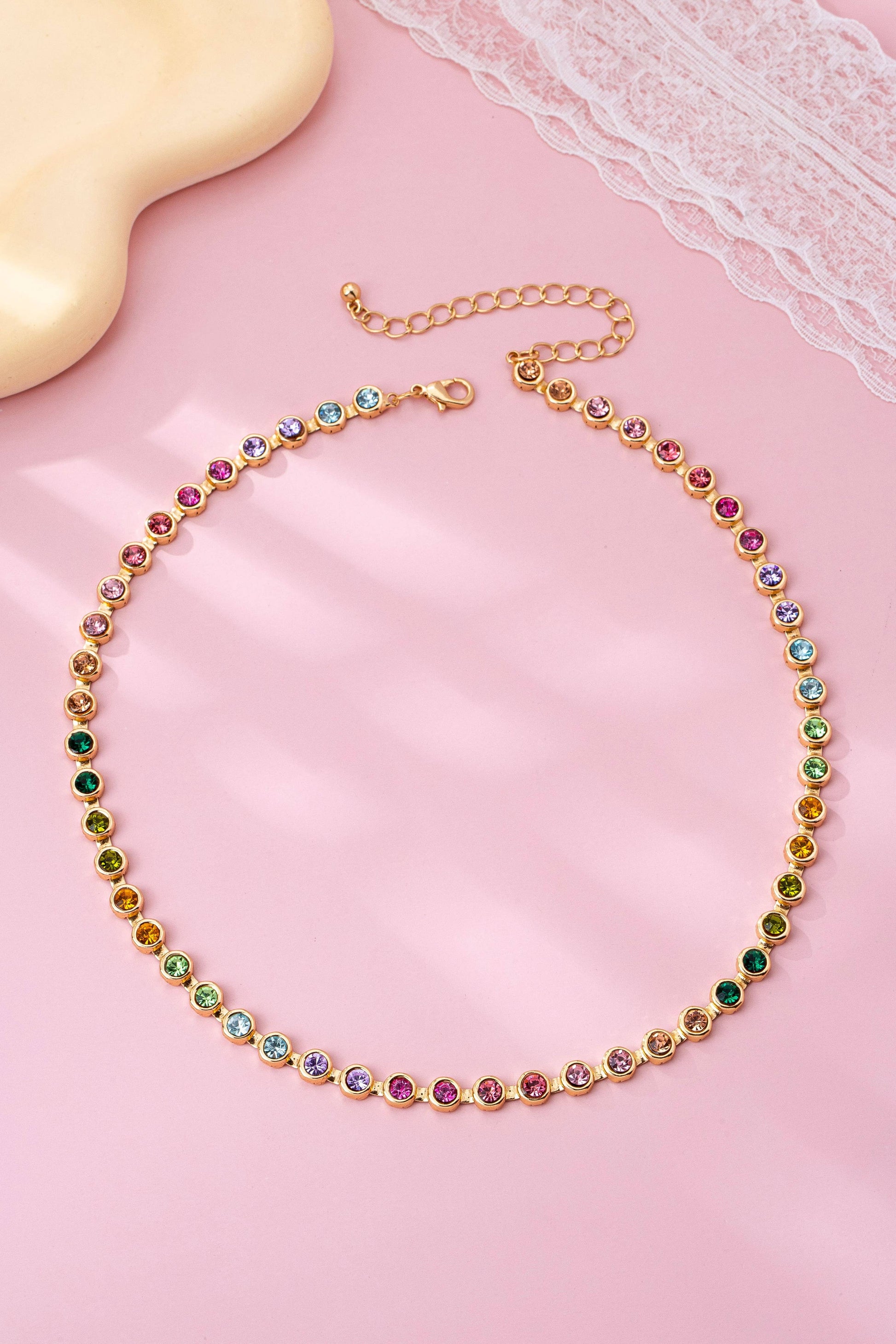 Necklace with multicolored beads on a pink surface