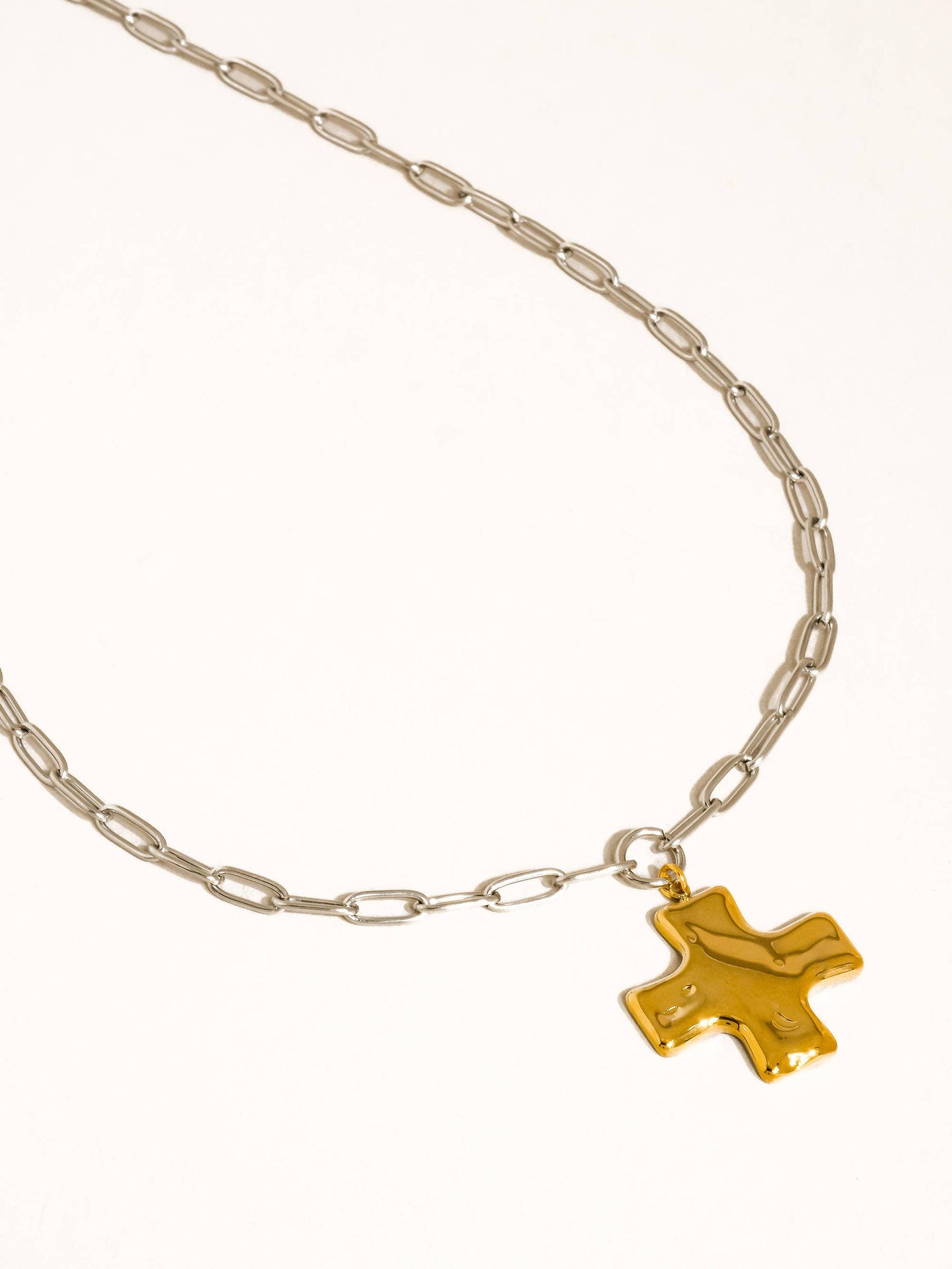 Necklace with a gold cross pendant on a white background