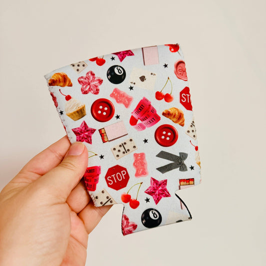 Hand holding a coffee sleeve with colorful pattern on a plain background