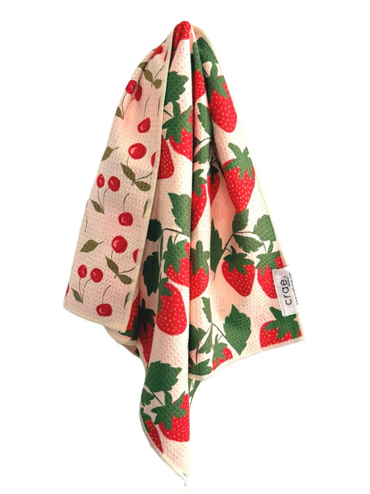 Kitchen towel with strawberry and cherry pattern on a white background
