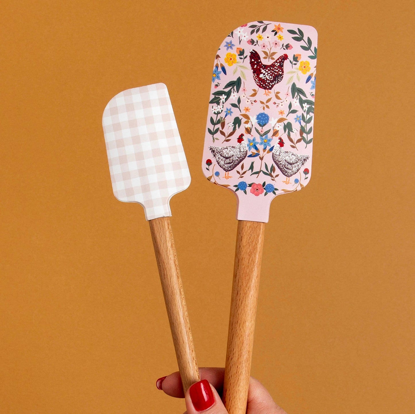 Two spatulas with decorative handles on a brown background