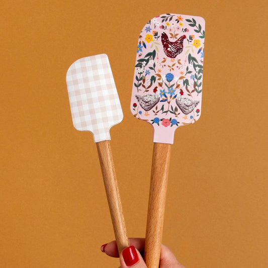 Two spatulas with decorative handles on a brown background