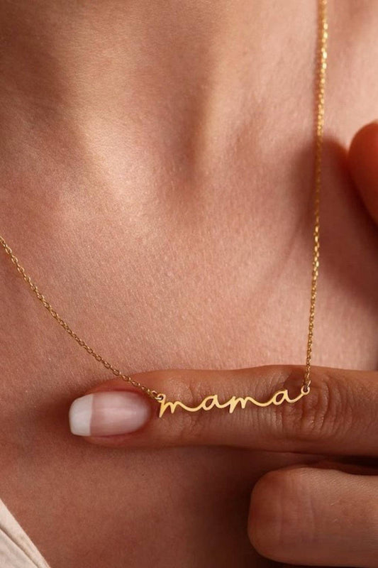 Gold necklace with 'mama' pendant on a person's neck