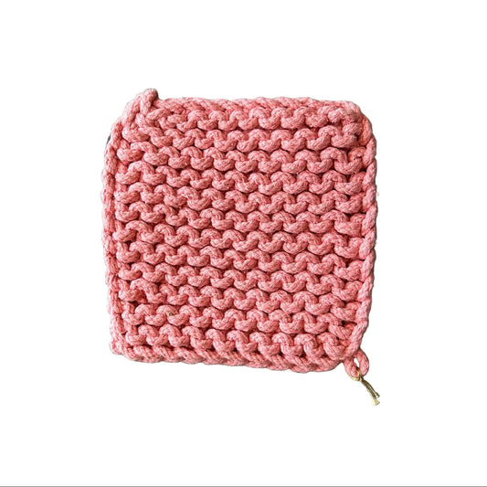 A square pink crochet potholder with a textured openwork pattern, laid flat on a white background