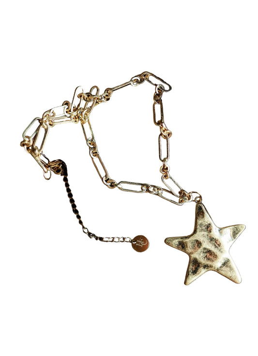 Gold star-shaped bracelet on a textured brown fabric background