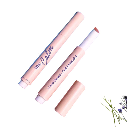 Two cylindrical products with 'Elys Calm' branding on a pink surface with lavender and flowers.