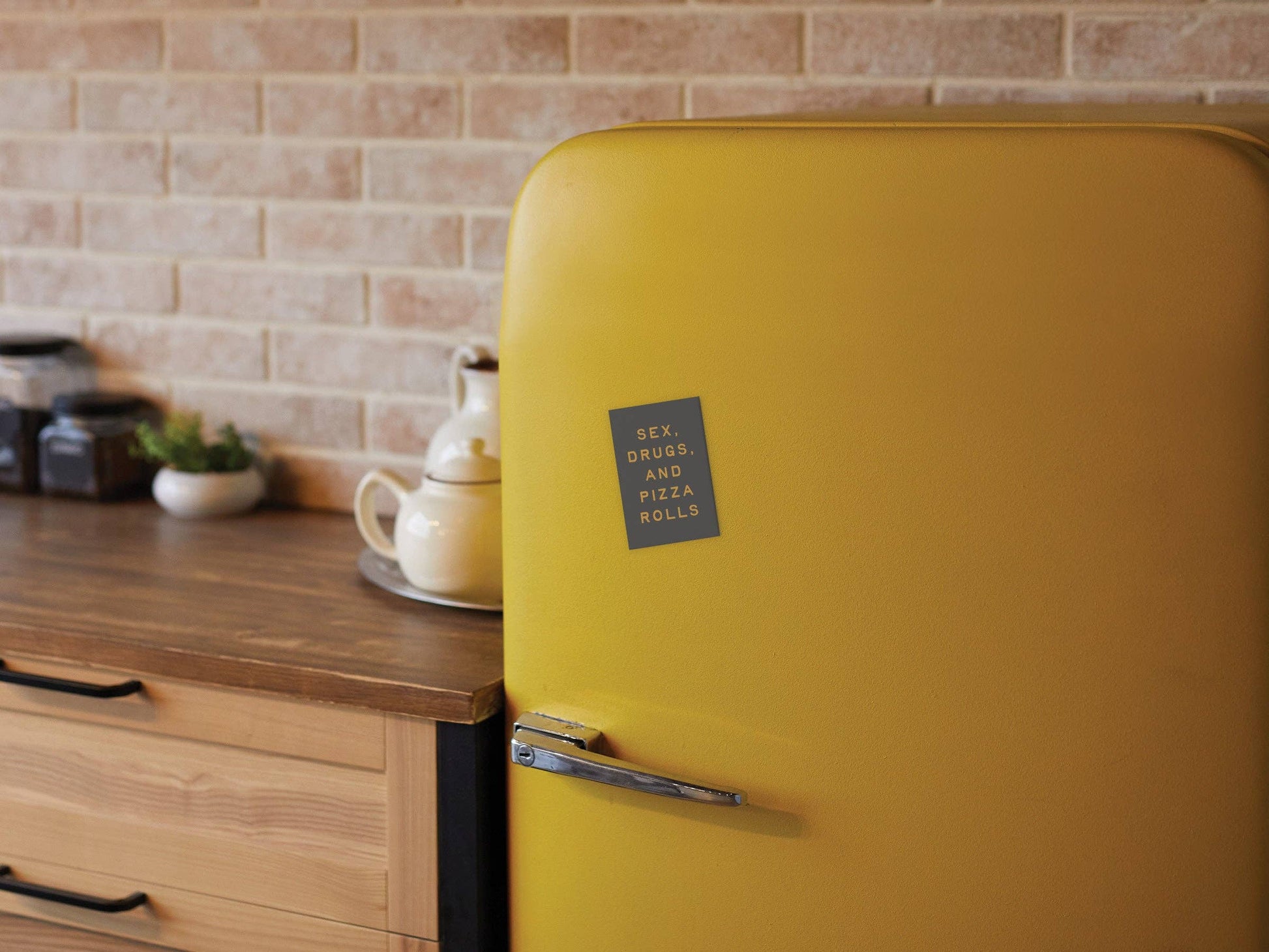 Yellow refrigerator with a sticker in a kitchen setting