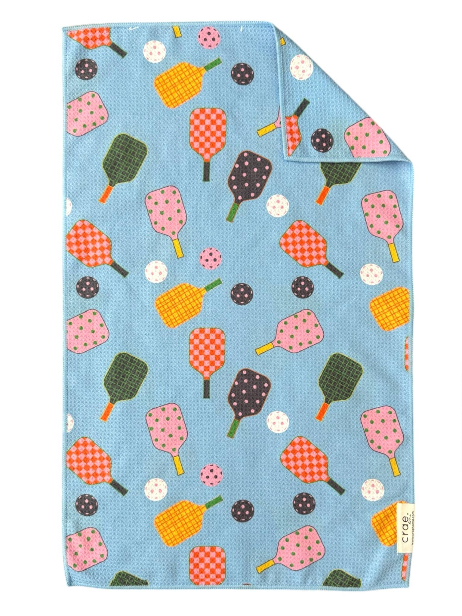 Blue tea towel with pickleball and pickleball paddle pattern on a white background