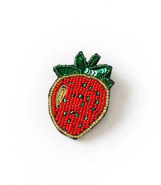 Strawberry-shaped brooch with bead detailing on a white background