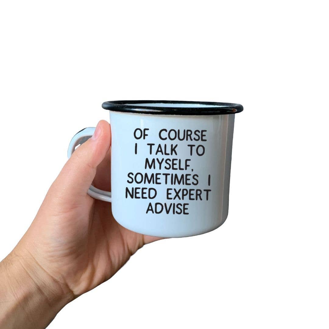 Hand holding a white mug with black text on a white background