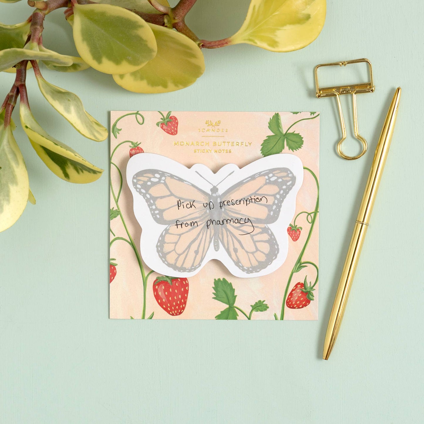 Butterfly-shaped prescription pad with strawberry design on a light green background