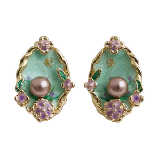 Pair of gold, oval shaped earrings with teal enamel background, light purple flowers and purple pearl center on a white background