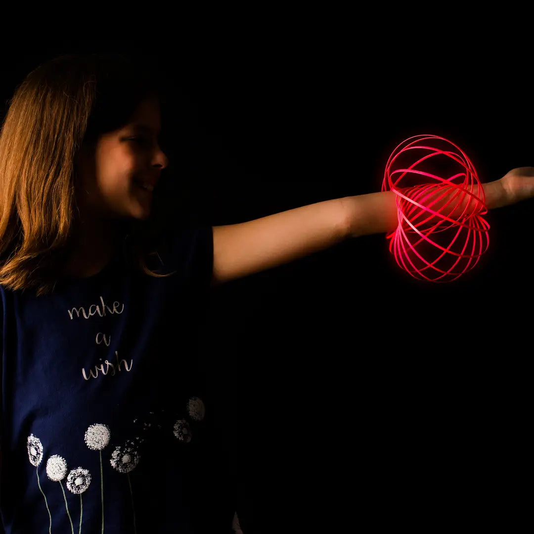 Child holding a glowing red ball against a dark background
