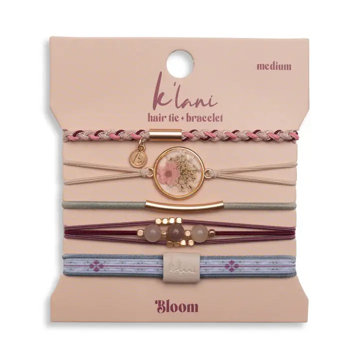 Set of hair ties and bracelets on a 'ke'lani' branded card with 'Bloom' design.