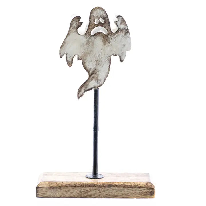 A ghost-shaped metal wall decor piece with a distressed silver finish, mounted on a black metal pole and a rectangular light brown wooden base, shown against a plain white background.