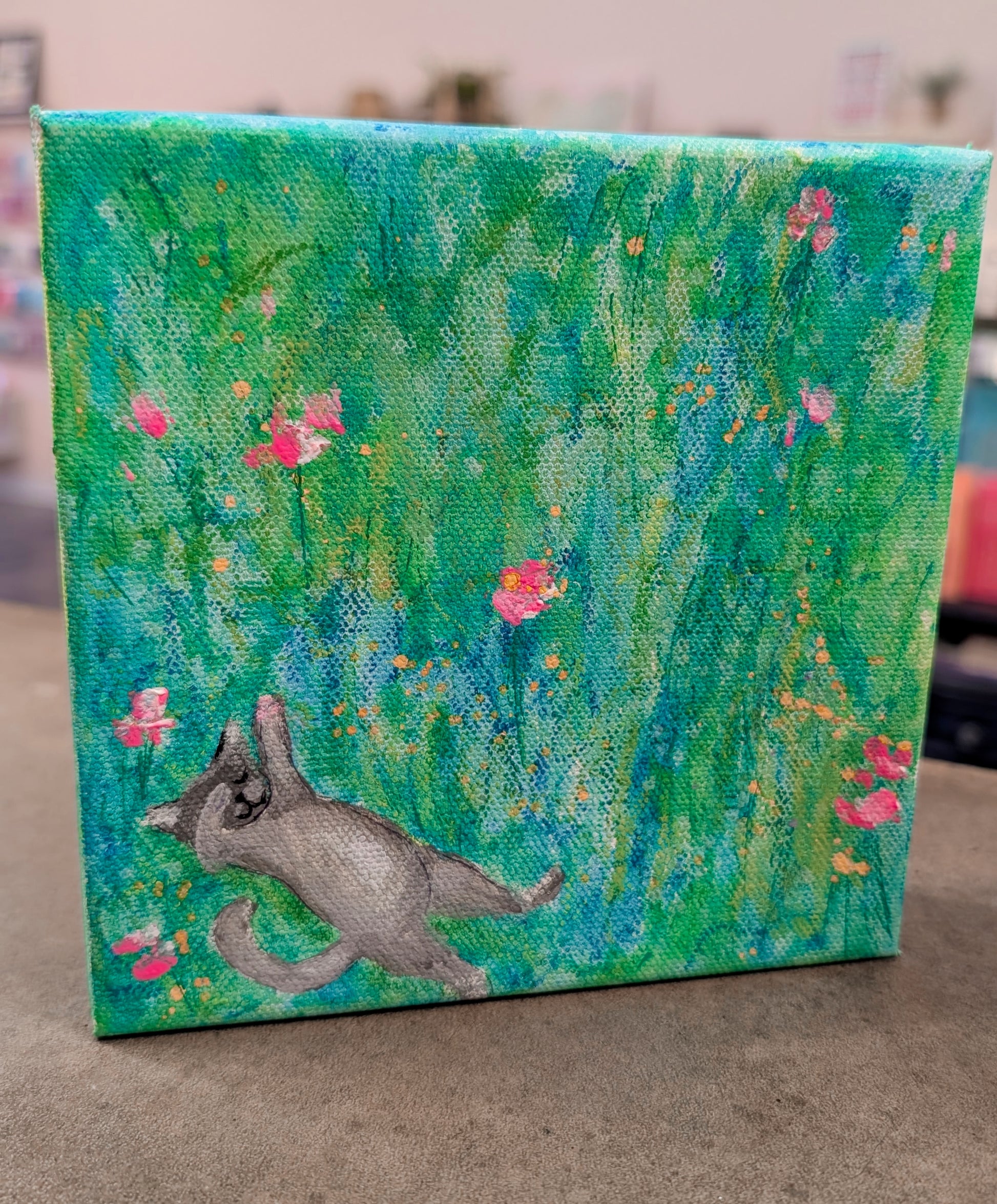 Canvas painting of a dog among flowers with a green and blue background