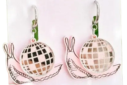 Earrings on a 'Medi Woods' branded card with grass background
