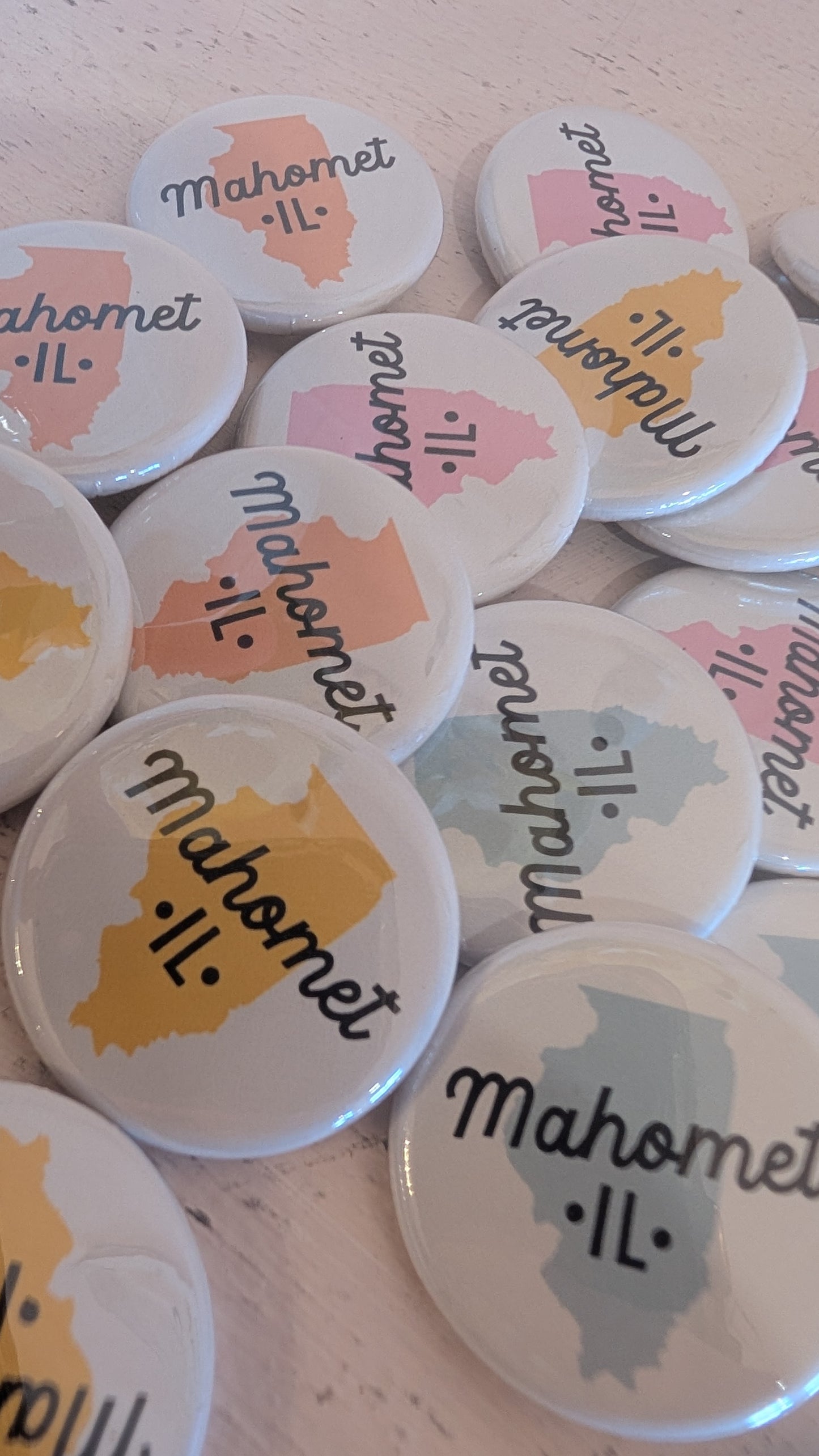 Collection of buttons with 'Mahomet, IL' text and map design on a light background