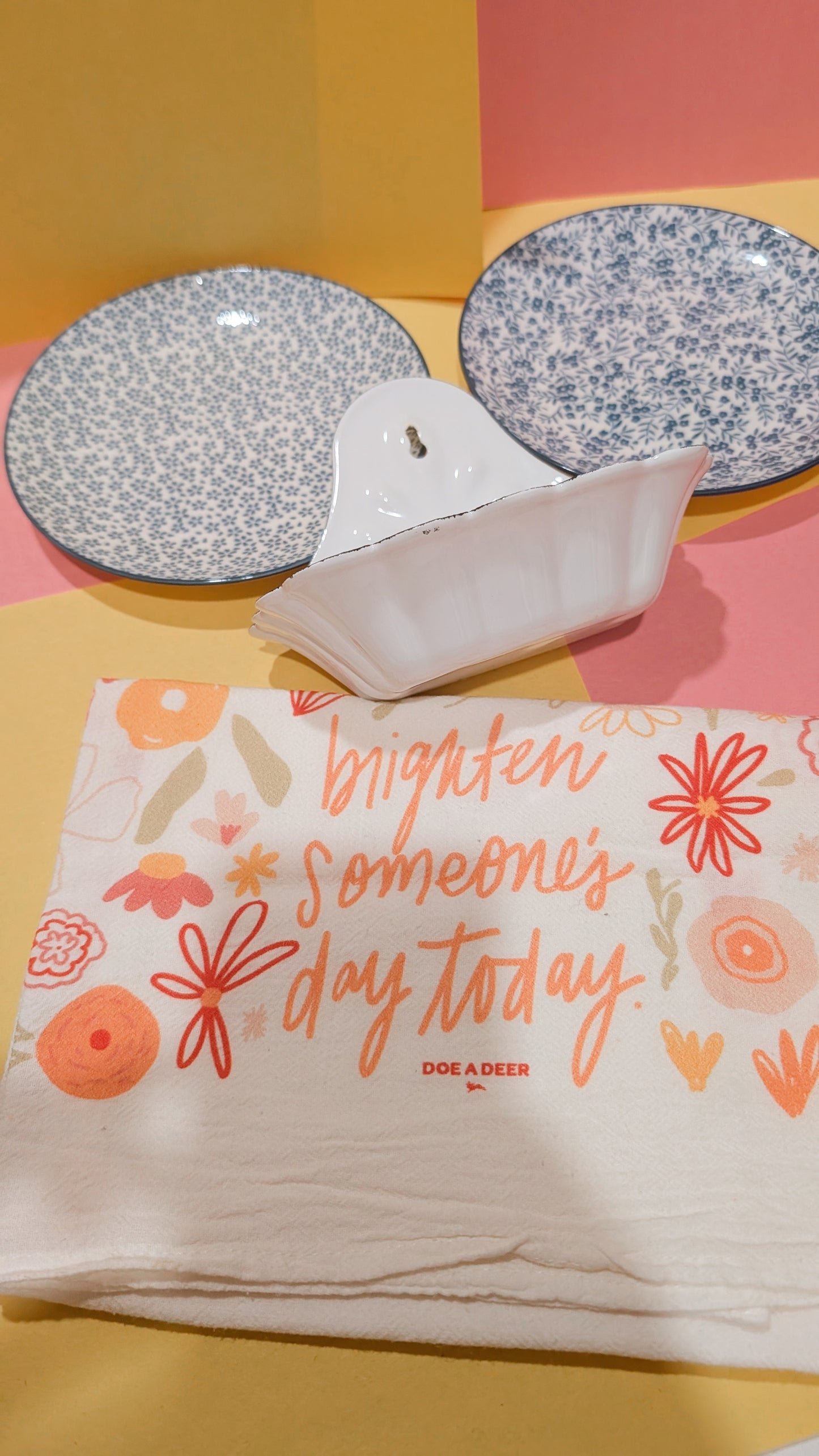 Two decorative plates with floral patterns on a colorful background, featuring a message about brightening someone's day.
