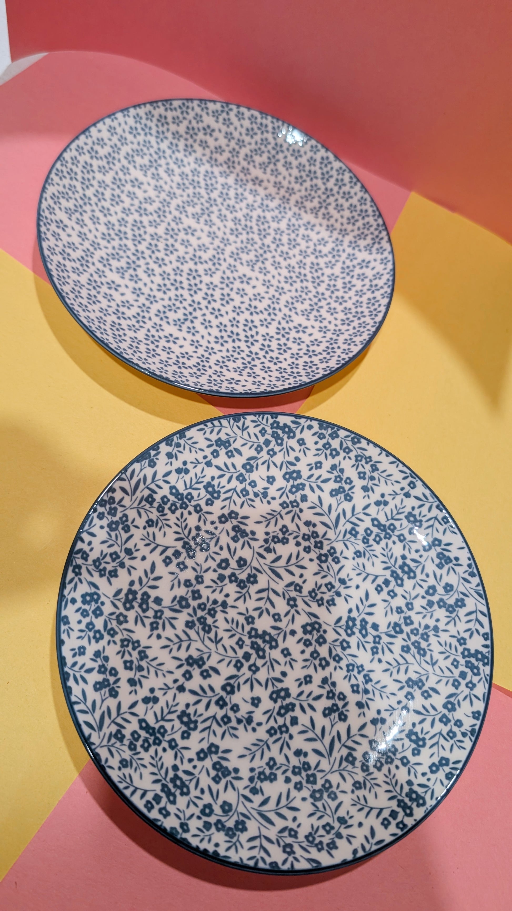 Two floral-patterned plates on a colorful background